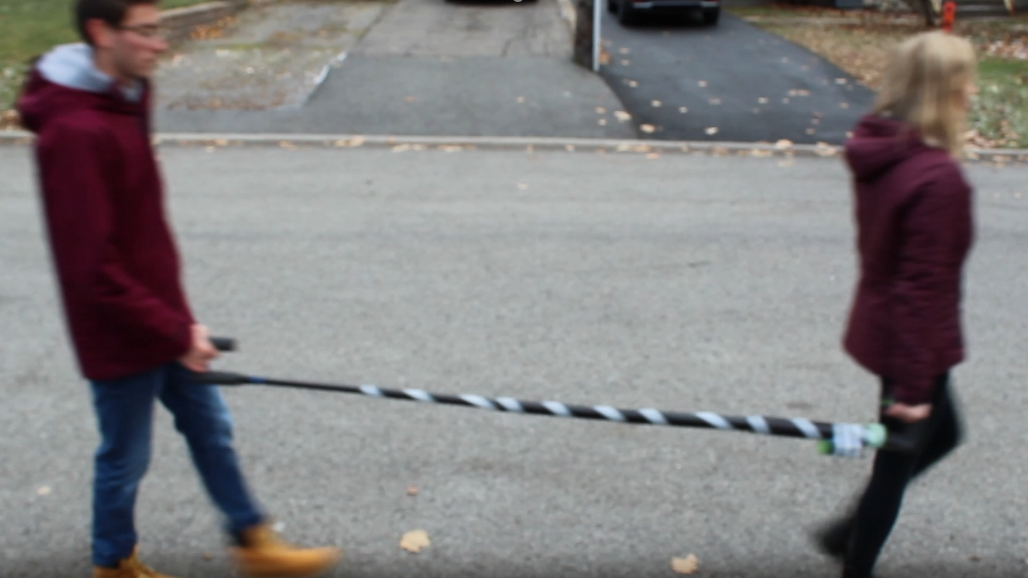 Two people using a guiding cane